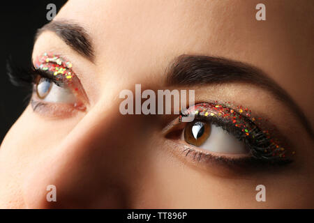 Purpurina maquillaje en una mujer hermosa cara sobre fondo negro Fotografía  de stock - Alamy