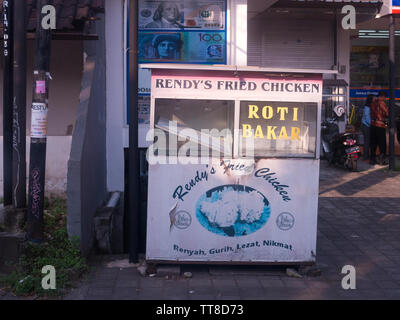 Vista de un puesto de comida en desuso titulado Rendys pollo frito en Bali, Indonesia