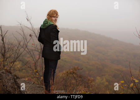 Mujer de pie en el campo contra el cielo Foto de stock