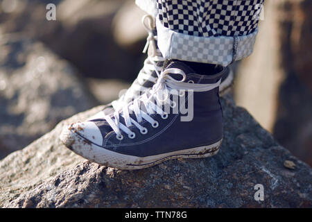 El pie humano en un sucio zapatilla en una vieja pelota de fútbol  Fotografía de stock - Alamy