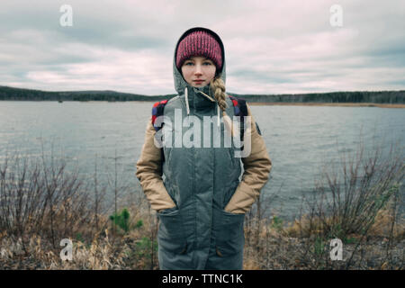 Retrato de mujer joven en ropa de abrigo por el río