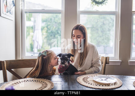 Familia multigeneracionales y pequeño perro comiendo tortitas de desayuno Foto de stock