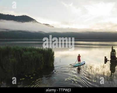 Una mujer sobre un lago paddleboarding
