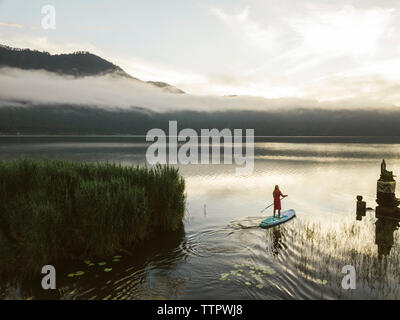 Una mujer sobre un lago paddleboarding