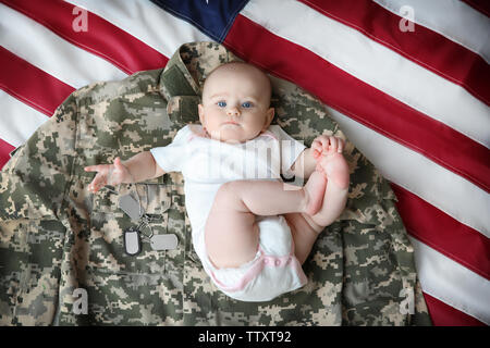 Lindo bebé ropa militar y la bandera Fotografía stock