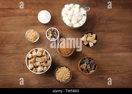 Diversos tipos de azúcar en recipientes en la mesa de madera Foto de stock