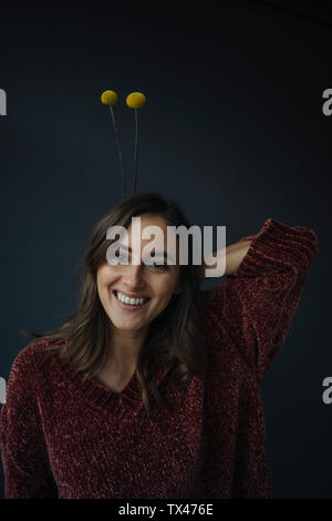 Retrato de mujer joven feliz portando flores en su cabeza