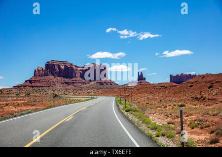 Monument Valley Navajo Tribal Park Road, en la frontera entre Arizona y Utah, Estados Unidos de América. Scenic Highway a formaciones de roca roja, día soleado en rep Foto de stock