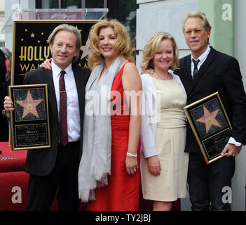 Dewey Bunnell (L) y Gerry Beckley (R), miembros del grupo de rock clásico y ganador de un premio Grammy, "el dúo América, sujetar placas de réplica después de que fueron honrados con el 2,459th estrella en el Paseo de la Fama de Hollywood durante una ceremonia en Los Angeles el 6 de febrero de 2012. Bunnell y Beckley se muestren con sus esposas Penny (2nd-L) y Kathy (3RD-L). UPI/Jim Ruymen Foto de stock