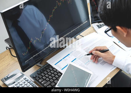 bursátil corredor de bolsa buscando trabajo gráfico analizar con pantalla, señalando los datos presentados y tratar sobre una e Fotografía de stock Alamy