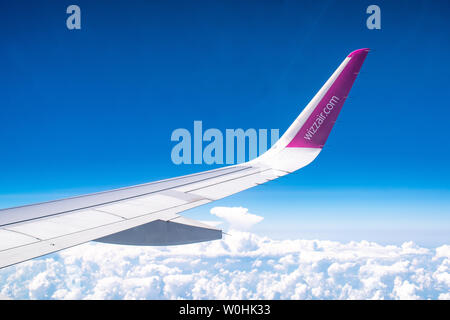 Wizzair logotipo o marca en la aleta, el cielo azul con las nubes desde el avión ver Foto de stock