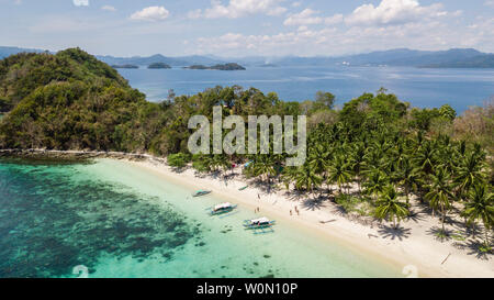 Vista aérea de una isla paradisíaca con algunos botes filipinos tradicionales en Palawan, Filipinas,
