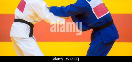 Dos luchadores de judo, en azul y blanco uniforme. Foto de stock