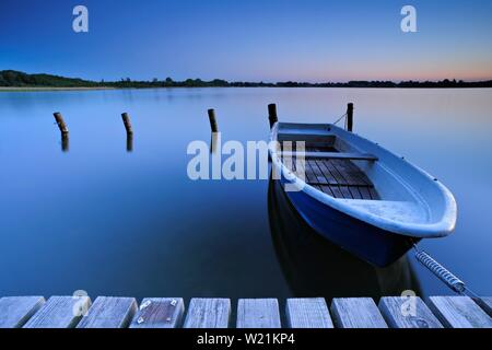 Lancha de desembarco con bote a remo, silenciosa, el lago al atardecer, Lago Schaalsee, Mecklemburgo-Pomerania Occidental, Alemania Foto de stock