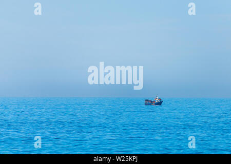 Imagen minimalista de la mar con un barco de pesca. El agua del mar y el azul claro del cielo Foto de stock