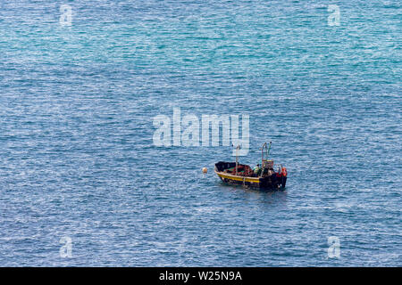 Imagen minimalista de la mar con un barco de pesca. El agua del mar y el azul claro del cielo Foto de stock