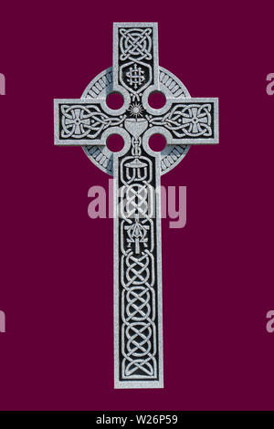 Una cruz celta de granito ornamental de la tumba de un sacerdote católico romano, mostrando el patrón Nudo celta, un cáliz de comunión, y el símbolo IHS Foto de stock