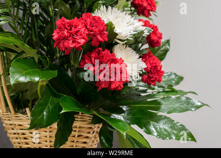 Ritual funerario cesta con flores sobre un fondo negro.El arreglo floral de las flores en la cesta es usado para funerales y marcadores. Mourni Foto de stock