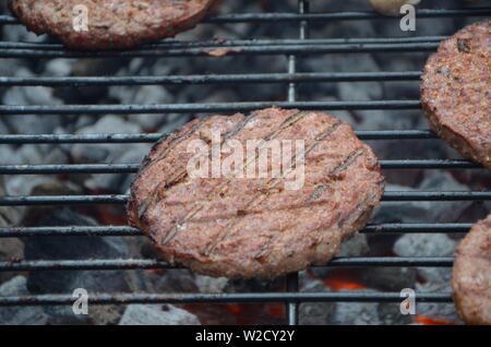 Las salchichas y hamburguesas de carne cocinar en la barbacoa