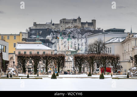 Vista de los jardines de invierno en el Palacio de Mirabell con fortaleza de Hohensalzburg en la distancia, Salzburgo, Austria Foto de stock