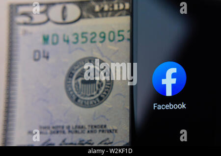 Facebook app icono junto al símbolo de la reserva federal 50 billetes de dólar. Ilustrar las Noticias sobre Facebook el lanzamiento de su propia moneda libra. Foto de stock