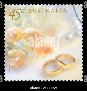 AUSTRALIA - circa 1999: un sello impreso en Australia muestra la imagen de los anillos de boda con rosas amarillas, serie de boda, circa 1999. Foto de stock