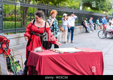 Nueva Orleans, EE.UU. - Abril 22, 2018: carta del Tarot psíquica lectura mujer de Palm en el vestido rojo traje de San Pedro por la calle de la Plaza Jackson, la gente caminando en Foto de stock