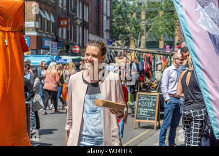 El aire libre y el colorido mercado callejero en Leather Lane durante un ajetreado durante la hora del almuerzo Foto de stock