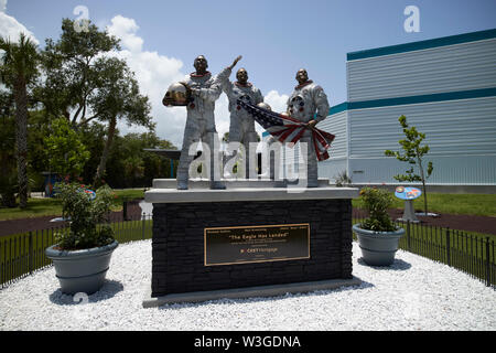 El Águila ha aterrizado escultura de tres astronautas en la luna nueva del árbol en el jardín Apollo/Saturn 5 Centro Centro Espacial Kennedy, Florida USA en el w Foto de stock
