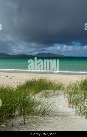 Una ducha de lluvia acercándose a las dunas en la playa Luskentire, Isla de Harris, Escocia Foto de stock