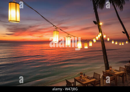 Romántica puesta de sol en la orilla de una isla tropical, Koh Chang, Tailandia. Café al aire libre en la playa. Foto de stock