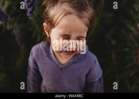 Close Up retrato de pequeño niño niña scrunching nariz y riendo
