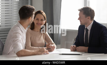 Feliz familia joven pareja haciendo decisión reunión gerente de banco asegurador Foto de stock