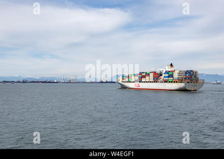 OOCL Amberes tirando de un buque portacontenedores en el puerto de Vancouver en Kaohsiung, Taiwán. Foto de stock