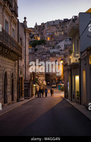 Vista desde un callejón en Ragusa Ibla a Ragusa Superiore al anochecer, Ragusa, Sicilia, Italia Foto de stock