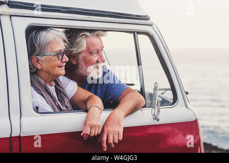 Las parejas ancianas viajando en una furgoneta vintage, contemplando el mar