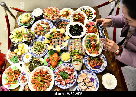 Los visitantes ver el Festival de Primavera de platos elaborados de polymer clay durante una exposición en la galería Laishaoqi en Hefei, al oriente de la ciudad de la provincia de Anhui, 25 Foto de stock