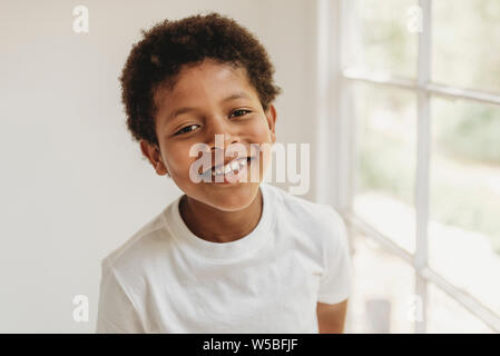Retrato de niño en edad escolar sonriente mirando a la cámara