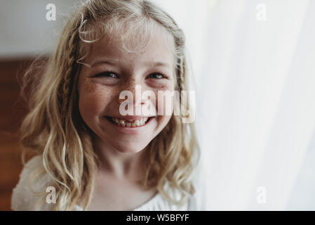 Retrato de joven chica sonriente pecoso diente que falta