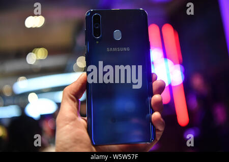 Un cliente intenta un Samsung Galaxy A8s smartphone durante el evento de lanzamiento en Beijing, China, 10 de diciembre de 2018. Samsung anuncia su primer Infini Foto de stock