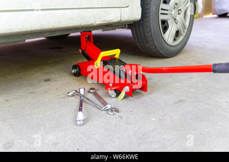 Herramienta de elevación del gato coche rojo para el mantenimiento y el  servicio de coches en alquiler de cuidado mantenimiento Fotografía de stock  - Alamy