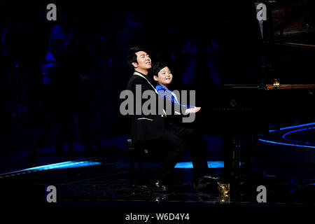 Pianista chino Lang Lang, izquierda, realiza durante el Cosmo Lady Show 2018 en Beijing, China, 26 de abril de 2018.