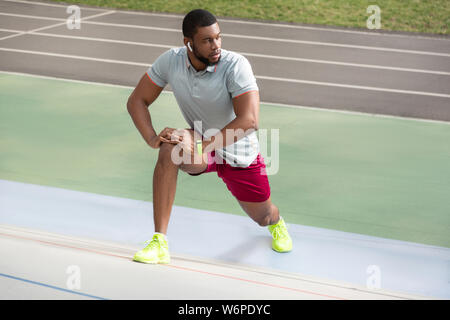 Seria atleta masculino de pie en la pista de atletismo Foto de stock