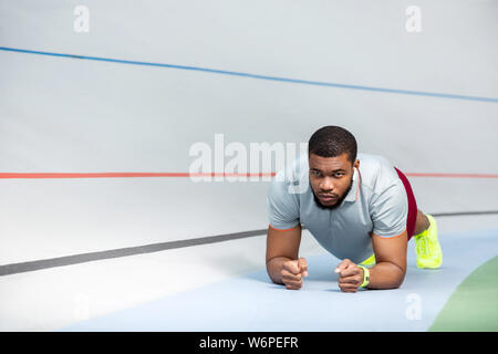 Joven deportista Afroamericano haciendo un ejercicio de tablones Foto de stock