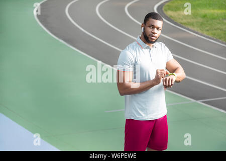 Colocar grave joven deportista con un fitness tracker Foto de stock