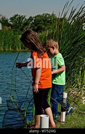 Mis nietos colocando bagre de canal en vivo, Lindsey Basquit Parque Público de pesca, Canyon Lake. Texas. Foto de stock
