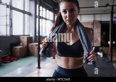 Mujer joven con toalla en el gimnasio Fotografía de stock - Alamy