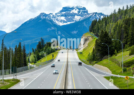 La Trans-Canada Highway en Banff - Un nublado día de primavera vista de la Trans-Canada Highway en la salida a Banff Townsite, con Mt. Bourgeau altísimos en segundo plano. Foto de stock