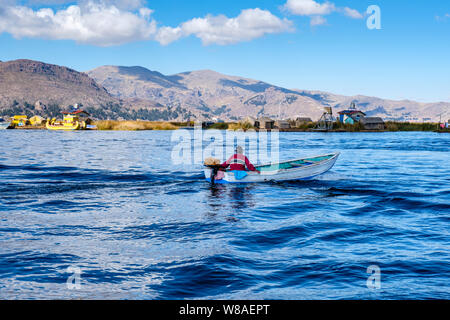 Lago Titicaca bote, pescador de cruzar el Lago Titicaca en bote de aluminio, las Islas de los Uros, Puno, Perú Foto de stock