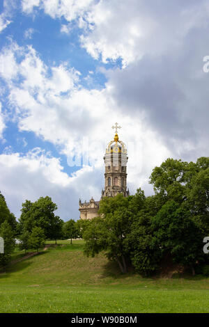 Templo de piedra con un alto campanario, una cúpula dorada y un golden cruz cristiana en la parte superior. Hermosa majestuosa iglesia cristiana ortodoxa en la finca de Du